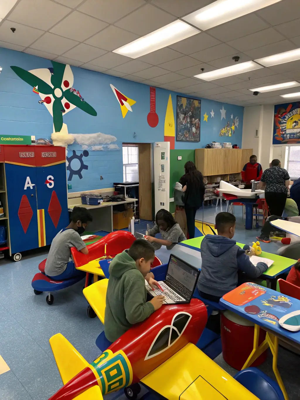 A classroom scene with young people learning about aeronautics, featuring technical diagrams and model airplanes, used to showcase educational initiatives.